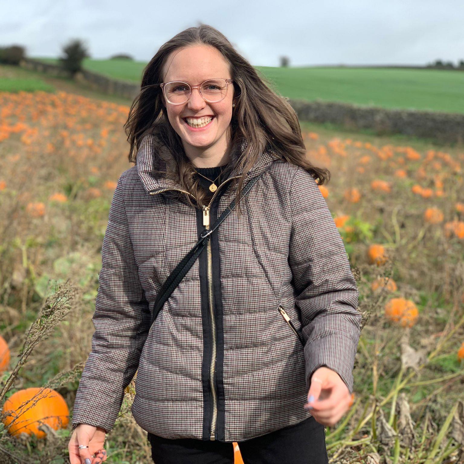 Lorna smiling in a pumpkin field